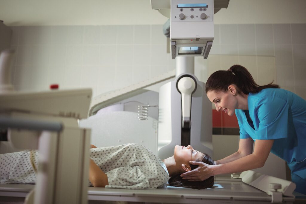 Tech assisting a patient with x-ray scanning.